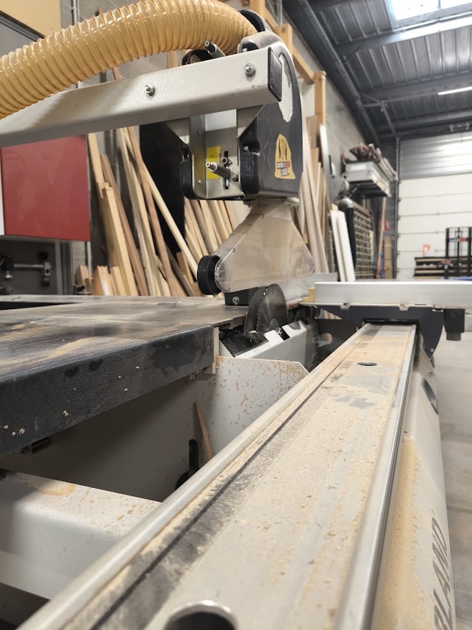 Scie à panneaux et bois stocké dans l’atelier